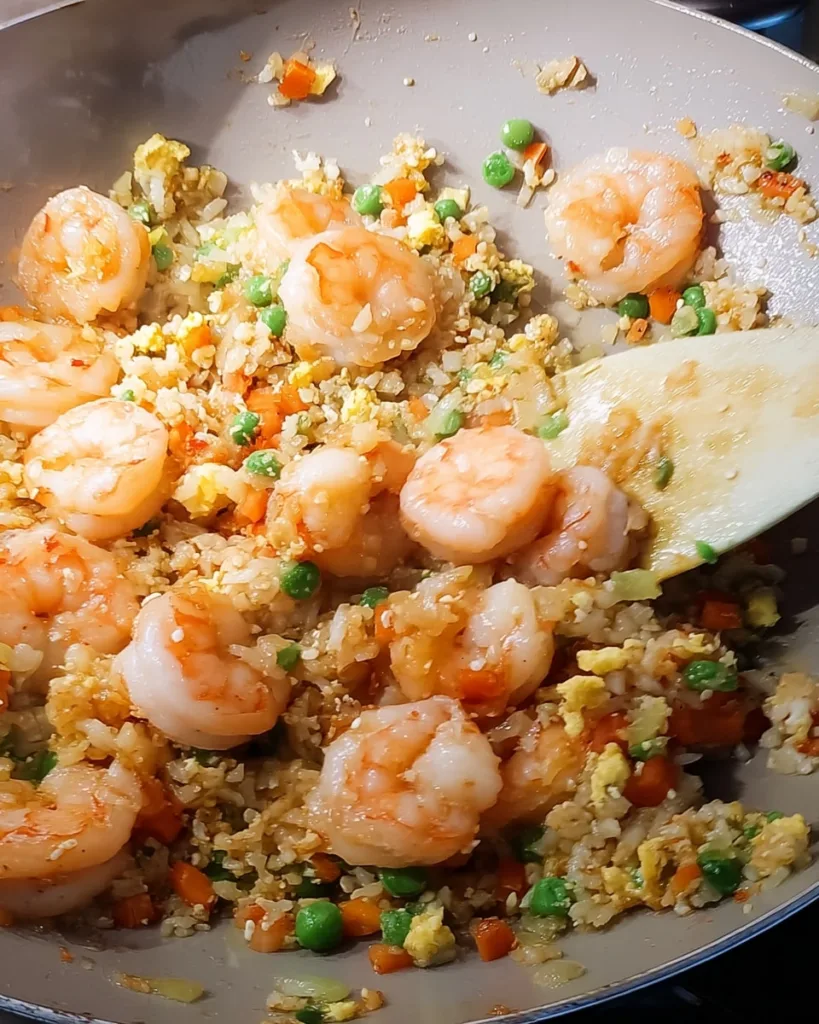 step-by-step shrimp fried rice cooking process with shrimp, eggs, and peas in a skillet