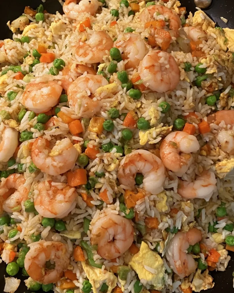 overhead view of shrimp fried rice meme dish in skillet with scrambled egg and vegetables