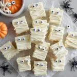 Mummy fudge squares decorated with candy eyes and white chocolate drizzle